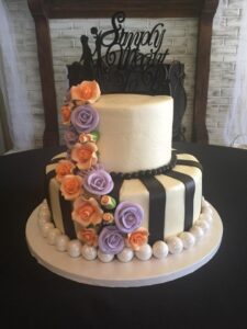 wedding cake with orange and purple iced roses